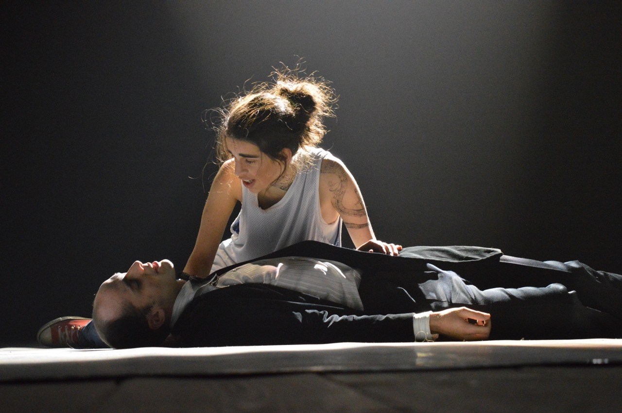 Jacopo Zerbo attore è sdraiato immobile sul palco ad occhi chiusi, su di lui lo sguardo di Francesca Zanin attrice in posizione raccolta al suo fianco in Ballad to Shakespeare di Palinodie.